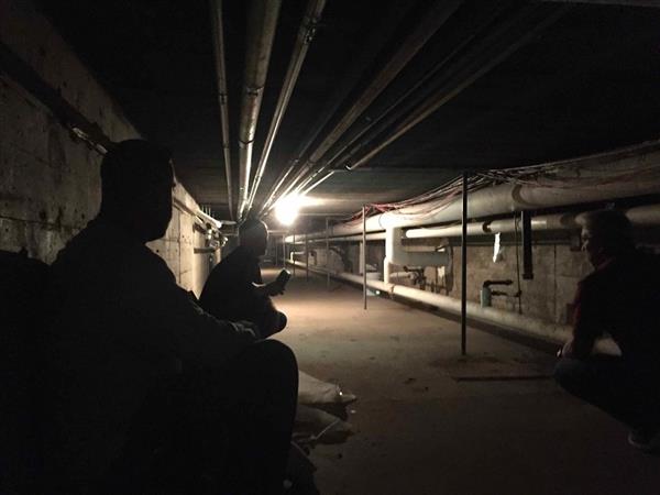 Contractors view the plumbing tunnel under the school's main corridor